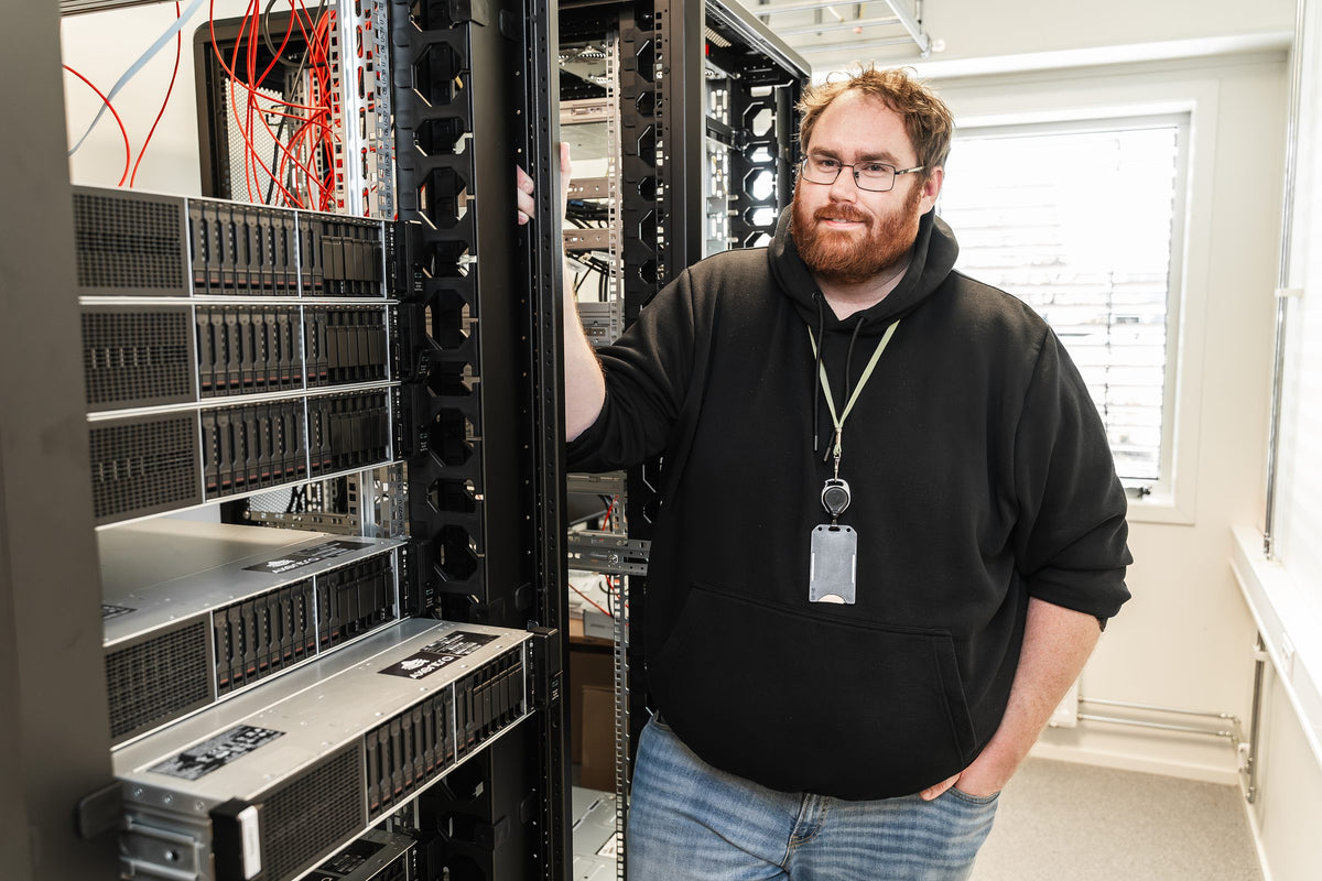 Faglærer Håvard Myrbakken står ved et serverrack med ni HPE ProLiant DL380 Gen10 Plus